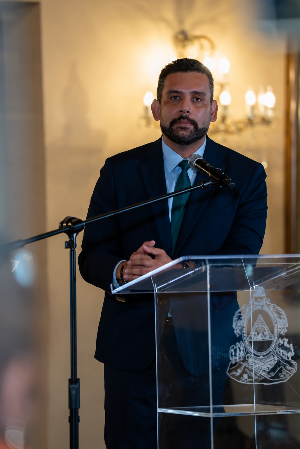 Hombre dirigiéndose desde un atril transparente.png